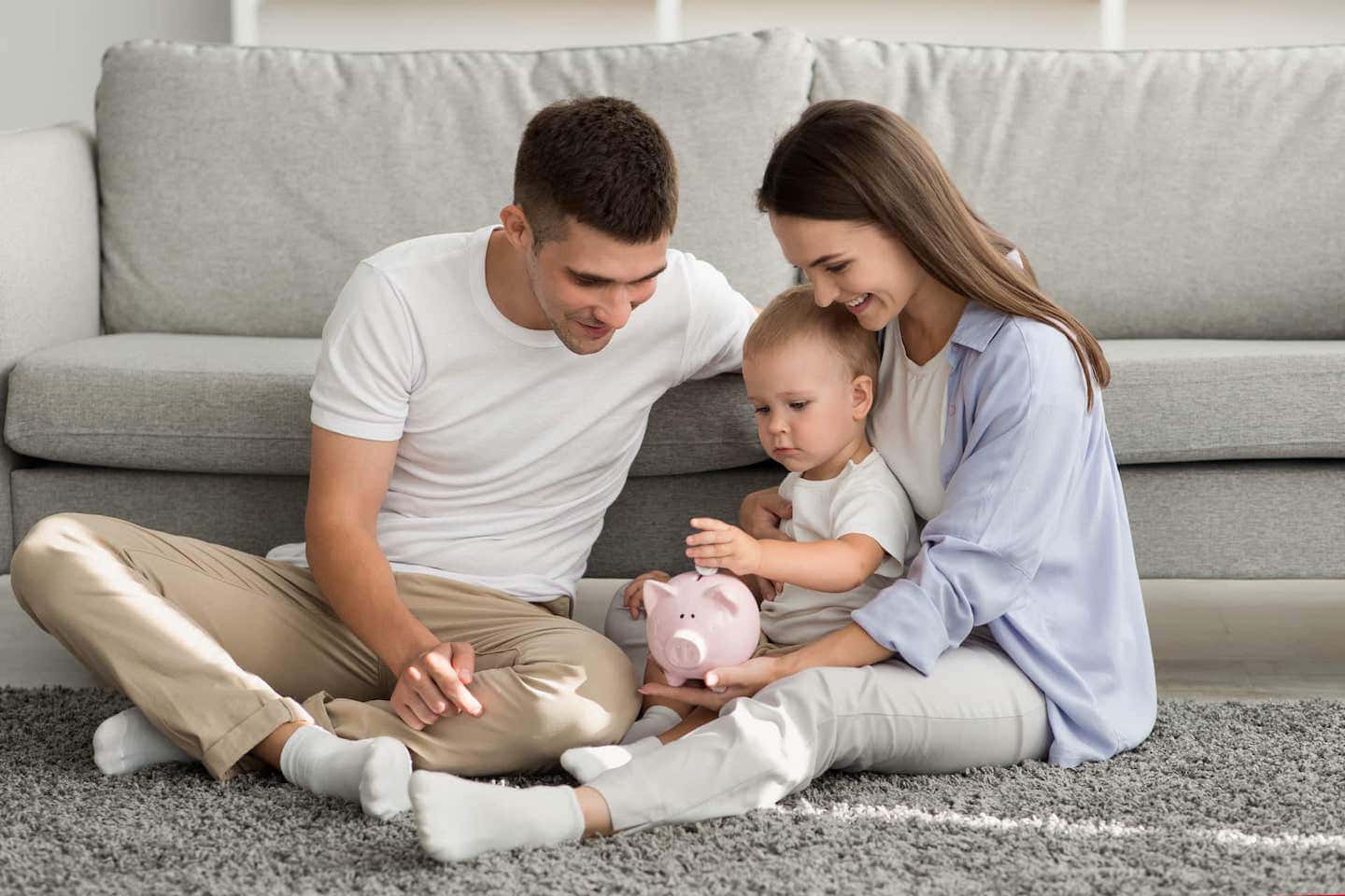 Famille: un couple avec un enfant insérant une pièce dans une tirelire.